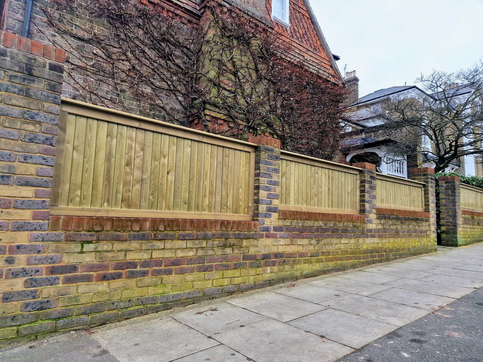 Image of Bespoke Fencing in Wimbledon SW19 with multiple customised panel sections built on top of brick wall between brick piers with one level top